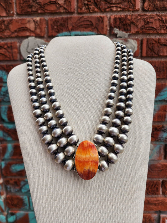 Spiny Oyster statement necklace with 3-strands of Sterling Silver beads on necklace display